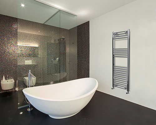 Large free standing bath in front of a walk in shower. Colour scheme of white and black